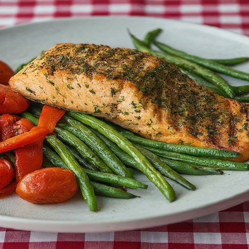 Plated grilled salmon with roasted vegetables.