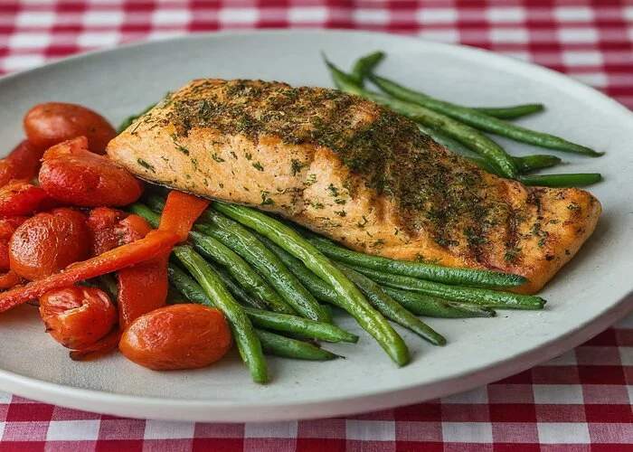 Plated grilled salmon with roasted vegetables.